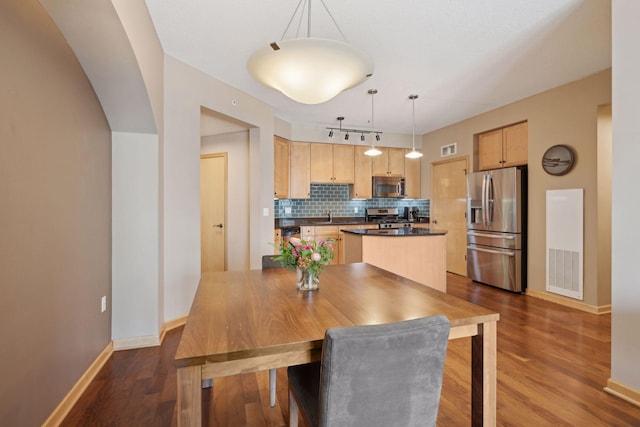 dining area featuring baseboards, visible vents, and wood finished floors