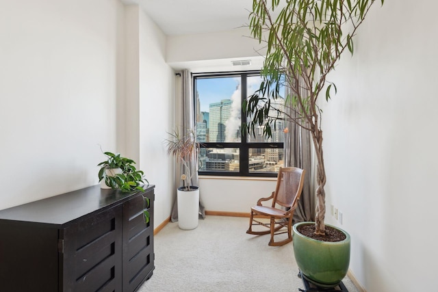 sitting room featuring a city view, carpet flooring, visible vents, and baseboards