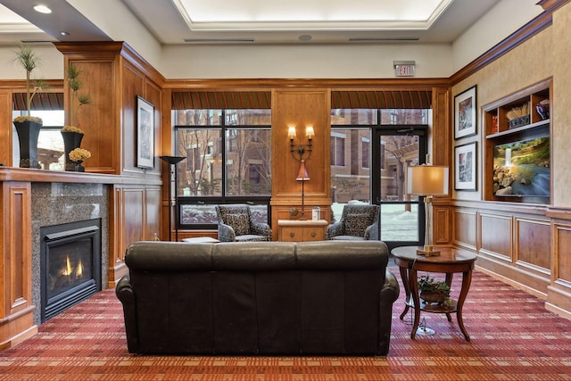 carpeted living room featuring a glass covered fireplace and a decorative wall