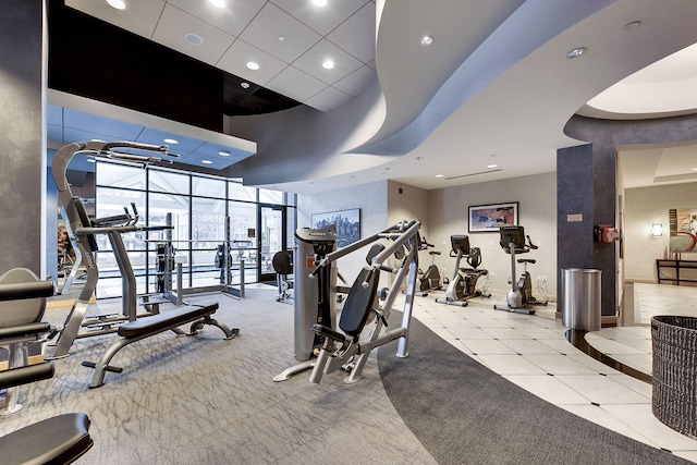 gym featuring light tile patterned floors, recessed lighting, light carpet, baseboards, and expansive windows