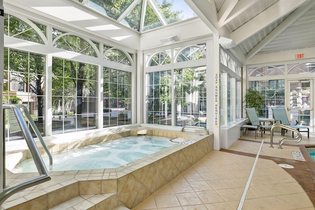 unfurnished sunroom with a skylight, a jacuzzi, and beam ceiling