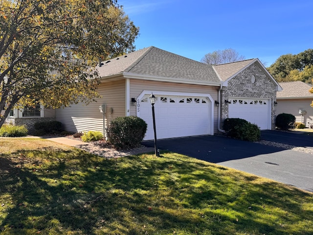 view of side of property with a lawn and a garage