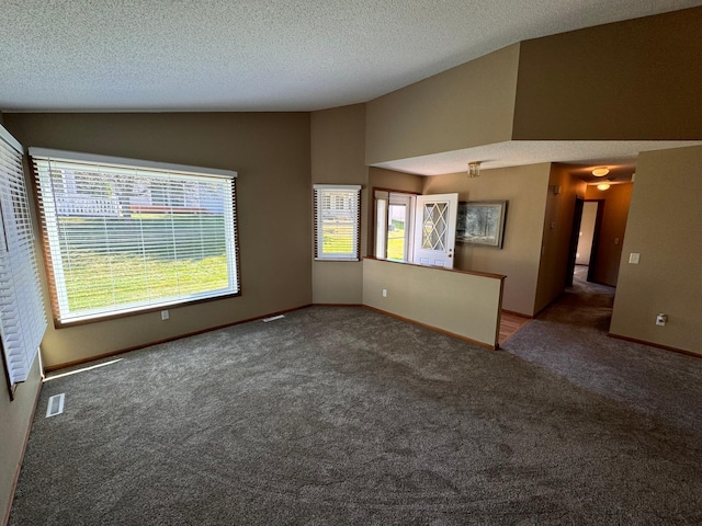 unfurnished living room featuring a textured ceiling, lofted ceiling, and carpet