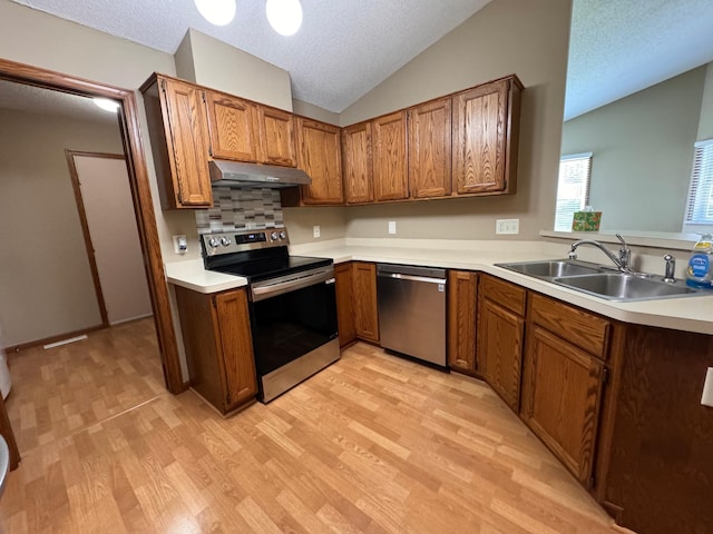 kitchen with light hardwood / wood-style floors, lofted ceiling, sink, and stainless steel appliances