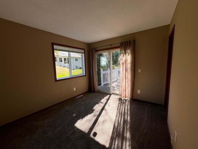 carpeted spare room with a textured ceiling