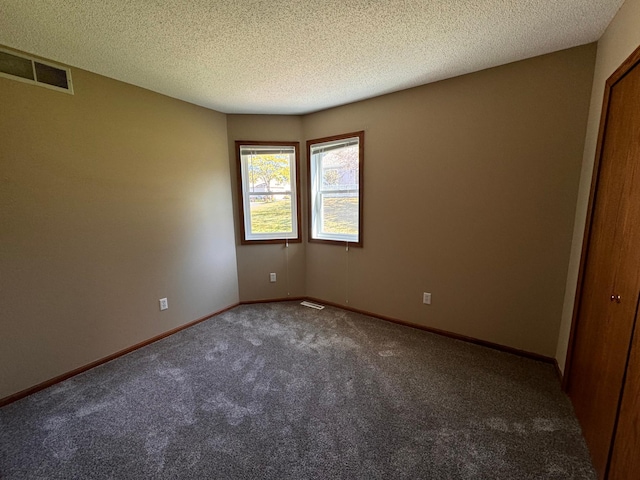 carpeted spare room featuring a textured ceiling