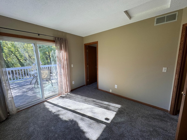 carpeted empty room featuring a textured ceiling