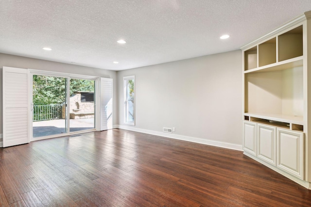 spare room with dark hardwood / wood-style flooring and a textured ceiling