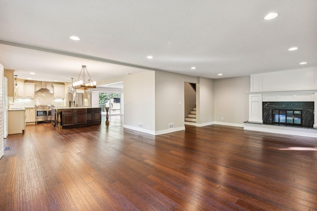 unfurnished living room with a high end fireplace and dark wood-type flooring