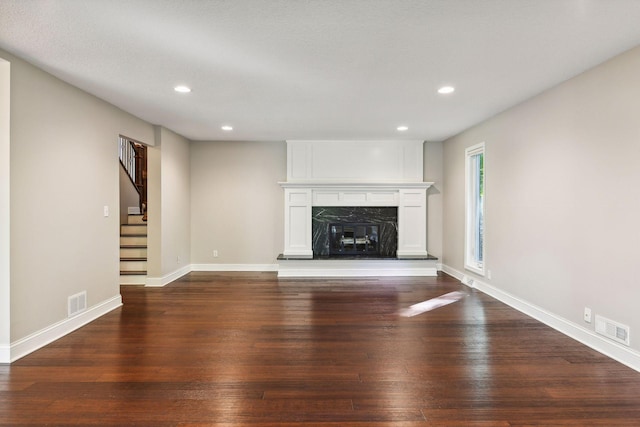 unfurnished living room with a fireplace and dark wood-type flooring