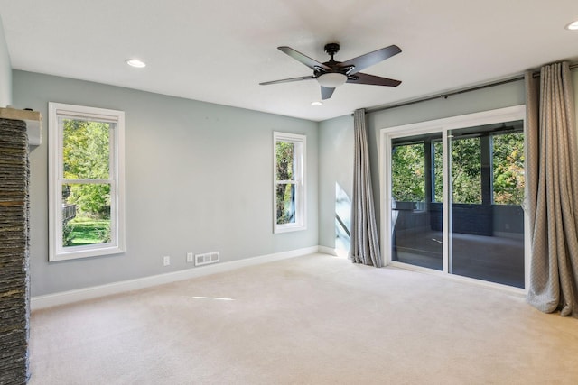 spare room featuring ceiling fan, plenty of natural light, and light colored carpet