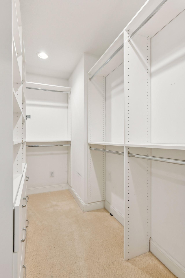 walk in closet featuring light carpet