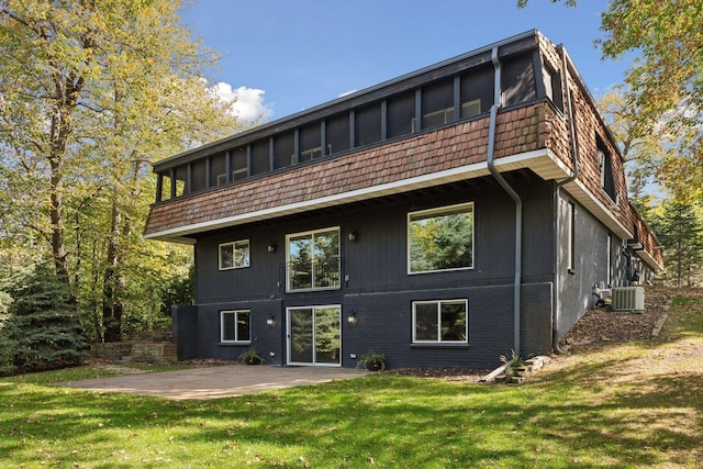 back of house with a sunroom, a yard, a patio, and central AC