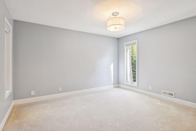 carpeted empty room with a textured ceiling