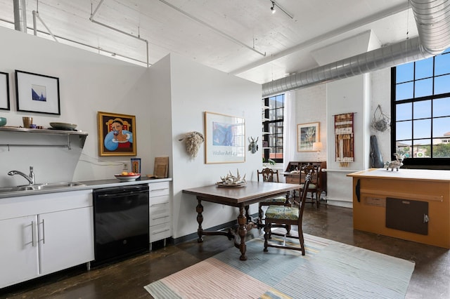 kitchen with a high ceiling, black dishwasher, white cabinetry, and sink