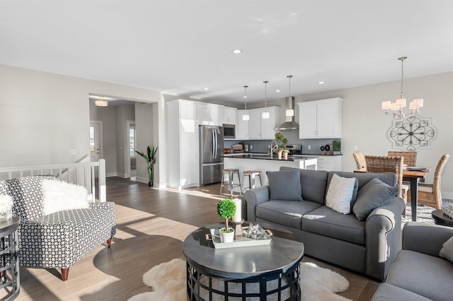 living room featuring sink, a chandelier, and hardwood / wood-style flooring