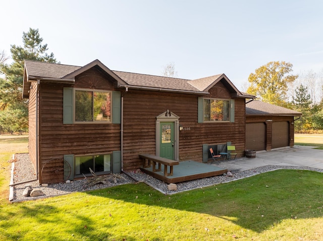 rear view of property featuring a garage and a yard