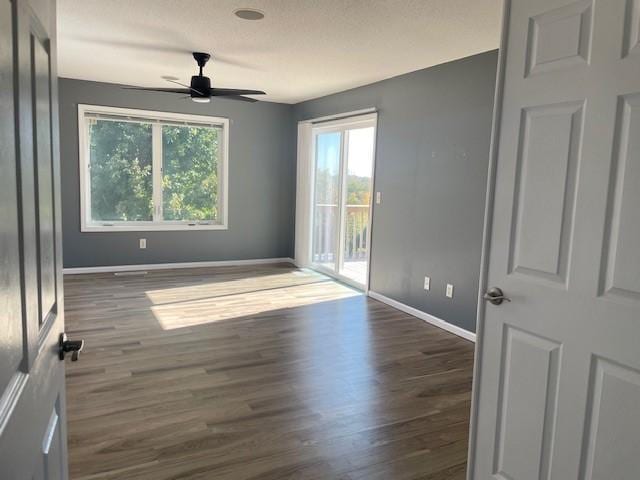 empty room featuring dark wood-type flooring and ceiling fan