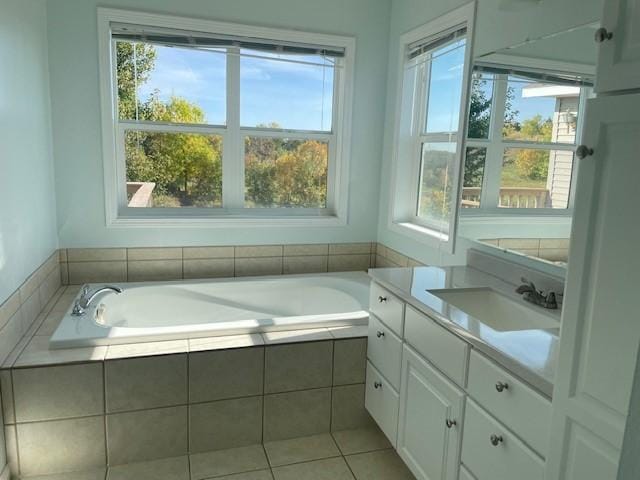 bathroom with vanity, tiled bath, and tile patterned flooring