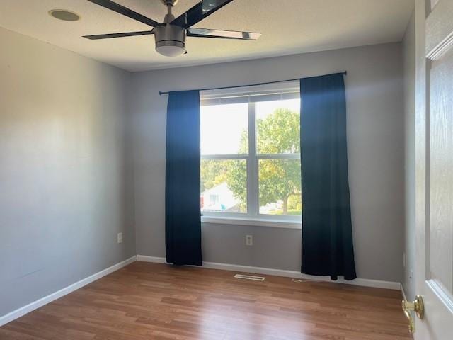 unfurnished room with ceiling fan and hardwood / wood-style floors