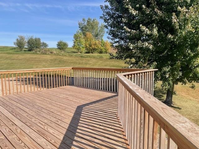 deck featuring a lawn and a rural view