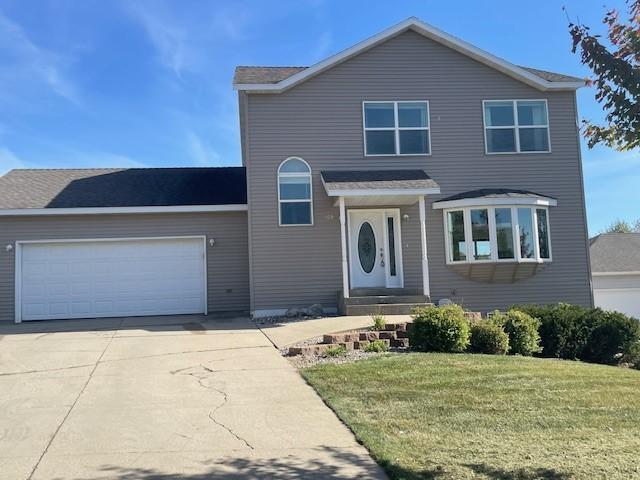 view of property with a garage and a front yard