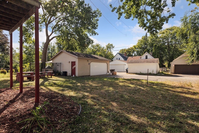 view of yard featuring a detached garage and an outbuilding