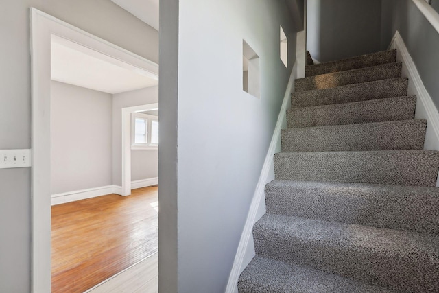 stairway featuring baseboards and wood finished floors