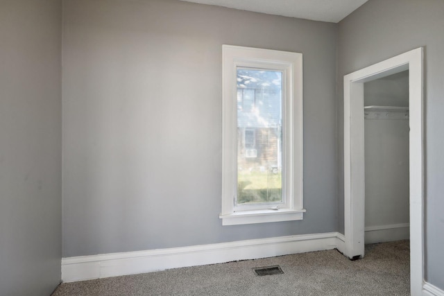 unfurnished bedroom with a closet, carpet flooring, and visible vents