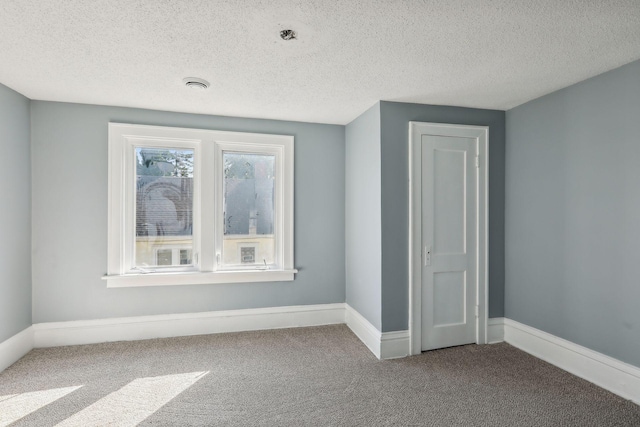 interior space featuring carpet, a textured ceiling, and baseboards