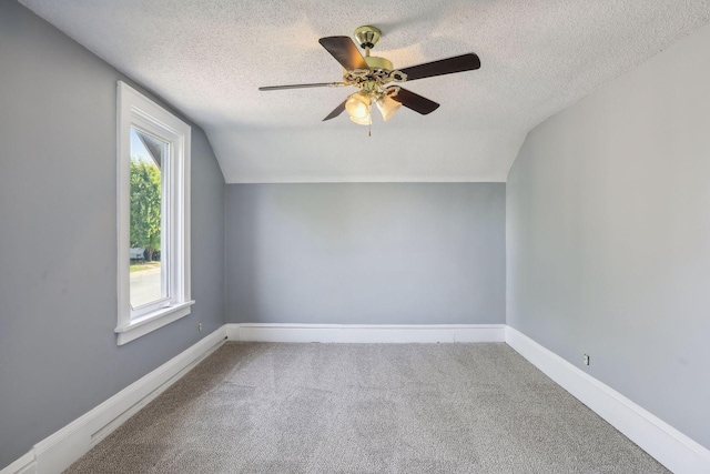 bonus room featuring baseboards, ceiling fan, carpet, vaulted ceiling, and a textured ceiling