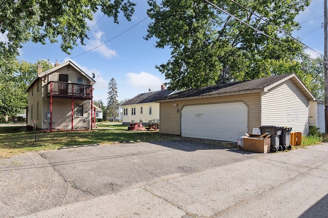 view of front of property with a garage, an outbuilding, and a front lawn