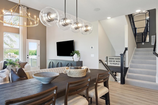 dining area with light hardwood / wood-style floors and a notable chandelier