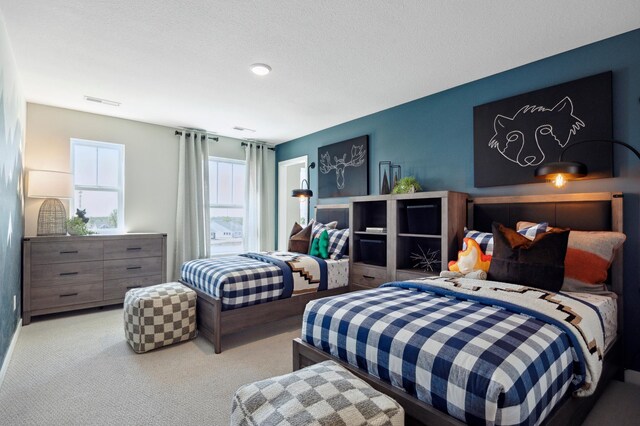 bedroom featuring a textured ceiling and light colored carpet