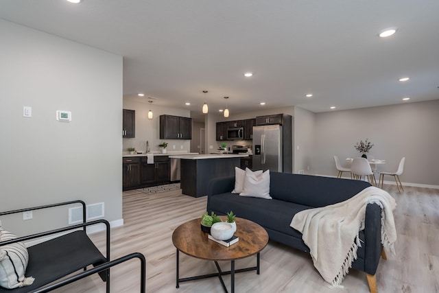 living room with light hardwood / wood-style floors and sink