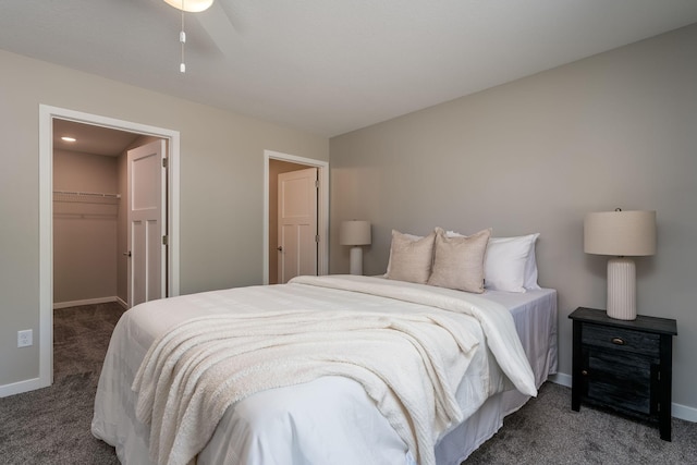 carpeted bedroom featuring a spacious closet, a closet, and ceiling fan