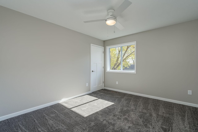 carpeted spare room featuring ceiling fan