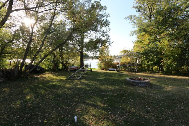 view of yard featuring a fire pit and a water view