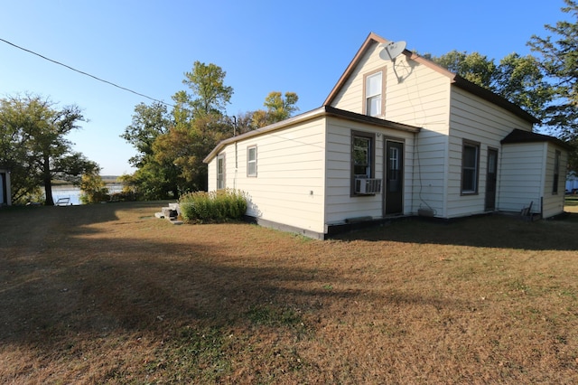 view of home's exterior with cooling unit and a yard