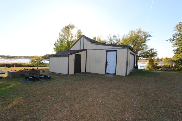 view of outdoor structure with a water view and a yard