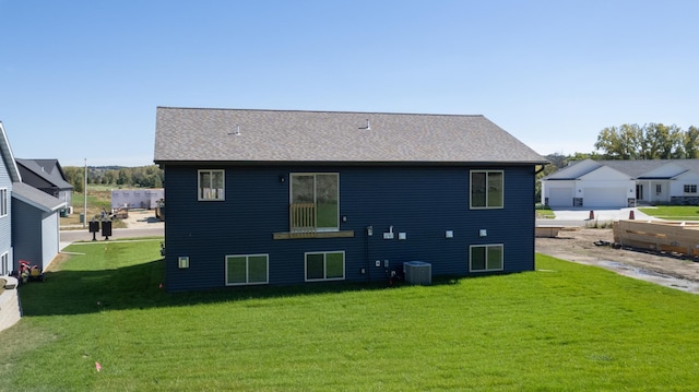 rear view of property featuring a lawn and central air condition unit