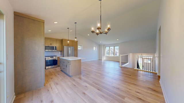 kitchen with a kitchen island, decorative light fixtures, appliances with stainless steel finishes, light wood-type flooring, and vaulted ceiling