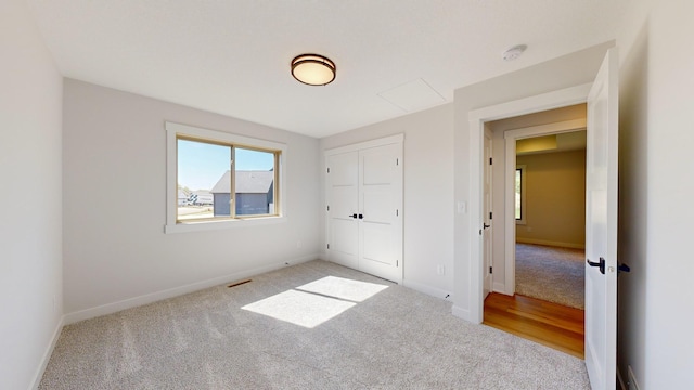 unfurnished bedroom with light carpet and a closet