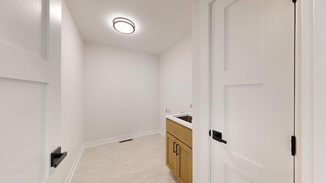 laundry room with a textured ceiling and light carpet