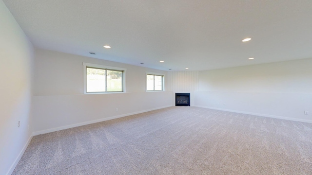 unfurnished living room with light colored carpet and a fireplace