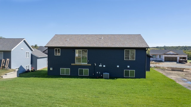 rear view of property featuring a lawn and central AC