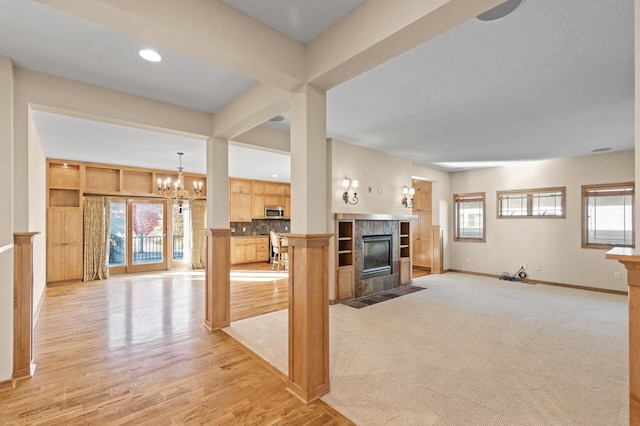 living room featuring a wealth of natural light, light hardwood / wood-style flooring, and a tile fireplace