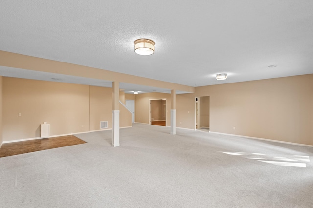 basement featuring a textured ceiling and carpet floors