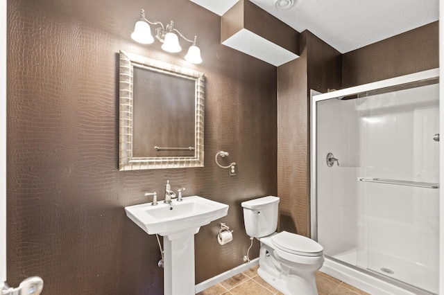 bathroom featuring tile patterned floors, toilet, sink, a textured ceiling, and an enclosed shower