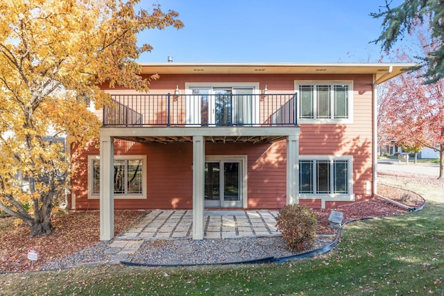 rear view of house featuring a patio area and a yard